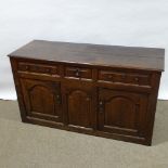 An 18th century oak dresser base, with fielded panelled cupboards and frieze drawers, length