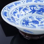 A large Chinese blue and white porcelain fish design bowl and hardwood stand, diameter 30cm. Crack