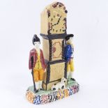 A rare Yorkshire Pratt Ware longcase clock group moneybox, flanked by a pair of figures and a dog in