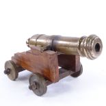 A bronze barrelled table cannon, on wooden carriage with bronze wheels, barrel length 18cm, probably