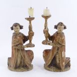 A pair of 19th century carved painted and gilded wood candleholders in the form of kneeling monks,