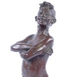 A patinated bronze sculpture of a young boy smoking a cigarette, early 20th century, signed on the