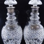 A pair of cut glass silver mounted decanters, with silver labels, height 29cm. Both decanters and