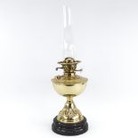 A Vintage embossed brass oil lamp on black ceramic base, with glass chimney, height to fitting