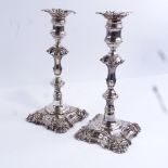 A pair of 19th century silver plated candlesticks, square bases with squirrel armorial crests,