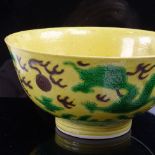 A Chinese yellow-ground Dragon bowl, depicting dragons chasing a flaming pearl, 6 character Kangxi