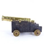 A heavy brass table cannon on wooden base, overall length 24cm. Good overall condition.