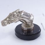 A nickel plate racing horse head car mascot, on painted metal base, overall height 8.5cm. Good