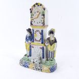 A rare Yorkshire Pratt Ware longcase clock group moneybox, flanked by a pair of figures and a dog in