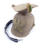 A German felt military helmet with embossed brass crest, replacement leather chin strap Top