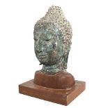 A Chinese verdigris bronze Buddha head, probably 17th or 18th century, mounted on modern woodblock