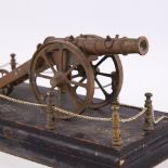 A 19th century style bronze cannon, on painted wood base with chain guard surround, base 31cm