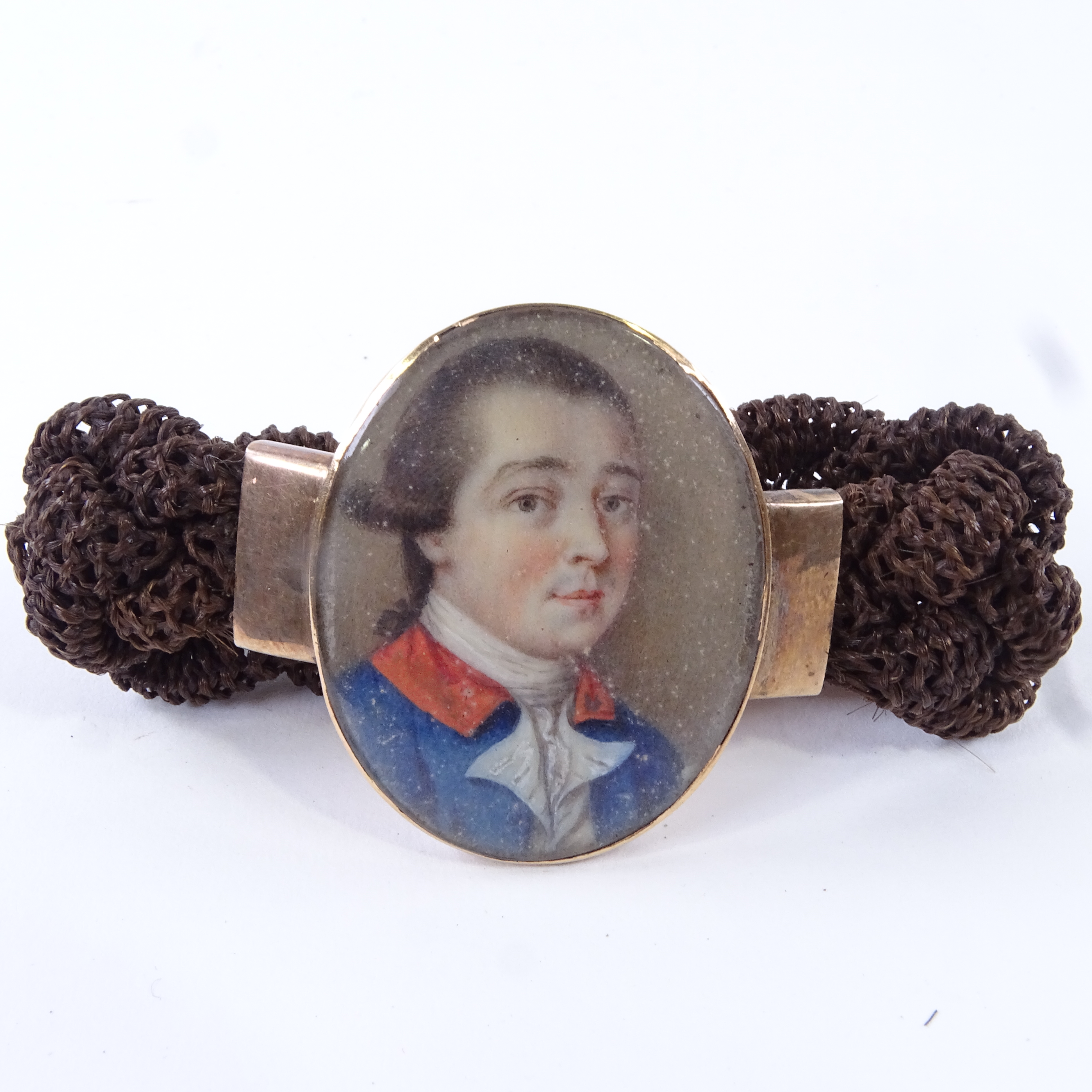 A Georgian woven hair bracelet with central miniature watercolour portrait on ivory, depicting a