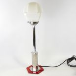 An Art Deco hexagonal table lamp, with chrome and bakelite body and white glass stepped shade,