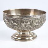 An early 20th century unmarked Indian silver pedestal bowl, relief embossed animal decoration,