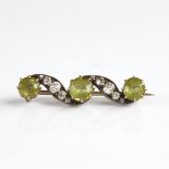 An early 20th century unmarked gold silver peridot and diamond brooch, total diamond content