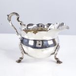 A late Victorian silver cream jug, bulbous form with fluted rim, scrolled acanthus leaf handle and