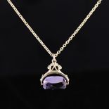 A late 20th century 9ct gold amethyst swivel fob pendant necklace, on unmarked gilt metal chain,