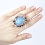 A large modern unmarked silver gem set ring, gemstones include cabochon turquoise, tourmalines and