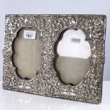 An Edwardian silver-fronted double-panel strut photo frame, all over relief embossed foliate