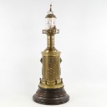 A large Victorian novelty brass lighthouse clock, painted glass rotating cylinder with Arabic