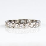 An unmarked white metal diamond eternity ring, total diamond content approx 0.8ct, band width 2.7mm,