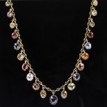 An Edwardian unmarked yellow metal gem set fringe necklace, set with graduated oval-cut gemstones,