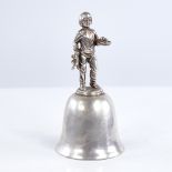 A late 20th century unmarked white metal dinner bell, figural design handle depicting boy with teddy