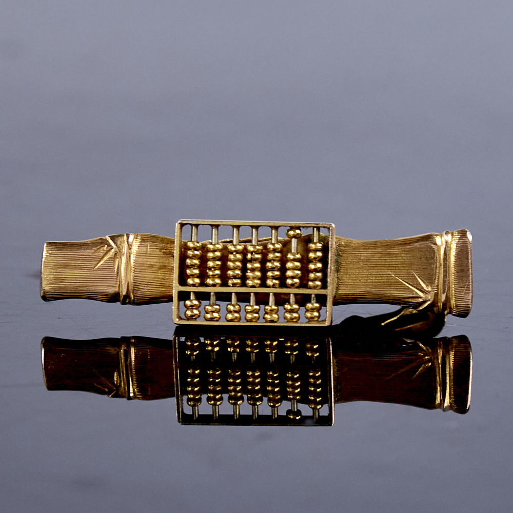 A late 20th century Chinese 14ct gold abacus tie clip, with engraved bamboo design background,
