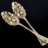 A pair of George III silver-gilt berry spoons, relief embossed bowls with chased decorated handle,