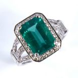 A rectangular emerald and diamond cluster ring, central large emerald step-cut emerald approx 3.