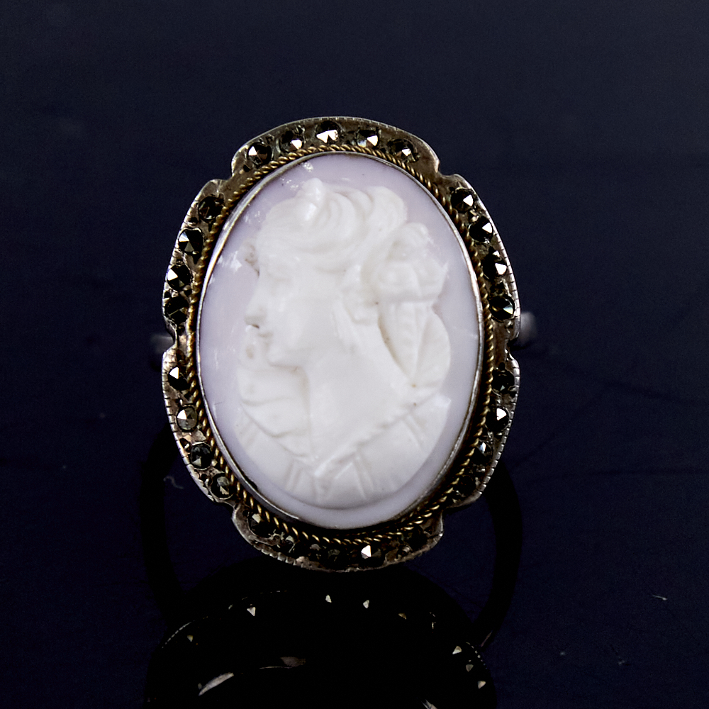 An early 20th century Continental silver relief carved pink coral cameo ring, surrounded by