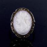 An early 20th century Continental silver relief carved pink coral cameo ring, surrounded by