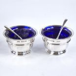 A George V silver salt and mustard cruet set, plain circular form with bead edge, with blue glass