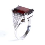 A modern 9ct white gold garnet and spinel dress ring, set with large emerald-cut garnet and eight-