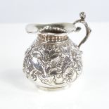 A Victorian silver squat cream jug, gourd form with relief embossed foliate decoration and figural