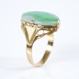 A Vintage Chinese unmarked high carat gold cabochon jade panel ring, ribbed shoulders with