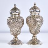 A pair of Victorian silver baluster pepperettes, allover relief embossed foliate decoration with