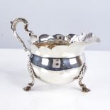 A late Victorian silver cream jug, bulbous form with fluted rim, scrolled acanthus leaf handle and