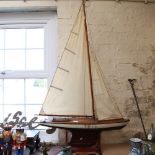 A large 19th century black and white lacquered wooden-hulled model pond yacht, with sails and