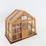 A small doll's house greenhouse with flowers and fittings, W23cm, H20cm, D13cm