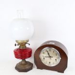 An Enfield 3-train mantel clock, and an oil lamp with red font, chimney and shade, height 48cm