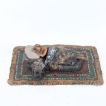 A novelty cold painted metal erotic sculpture, in the manner of Bergman, depicting woman laying on a