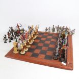 A Vintage leather covered chess board with a set of brass Tribal themed chessmen, and a set of