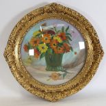 An ornate gilt-gesso circular frame, circa 1900, with convex glass front, containing a still life