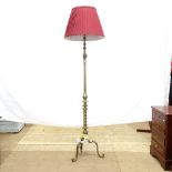 A turned brass standard lamp on tripod base, and a red fluted shade, lamp height to top of bayonet