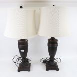 A pair of Antique style black painted metal urn lamps and shades, overall height 74cm