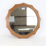 Edward Barnsley (Cotswold School), a circular wall mirror with shaped and inlaid walnut frame,