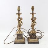A pair of polished cast-brass figural boy table candlesticks, on veined black marble bases,