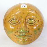 A large yellow and green glaze plaster man in the moon wall sculpture, unsigned, diameter 30cm